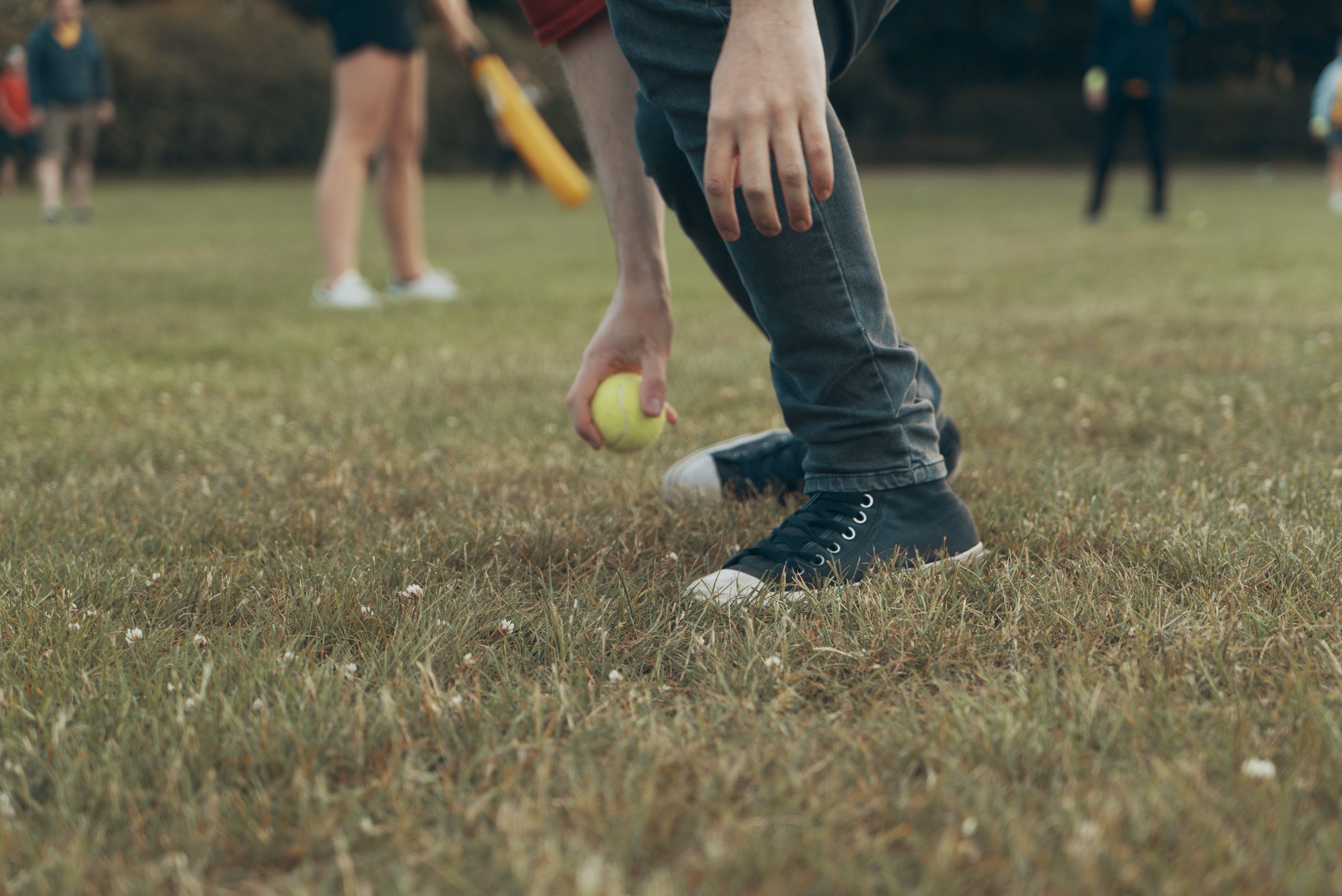 selective focus photography of man holding green baseball